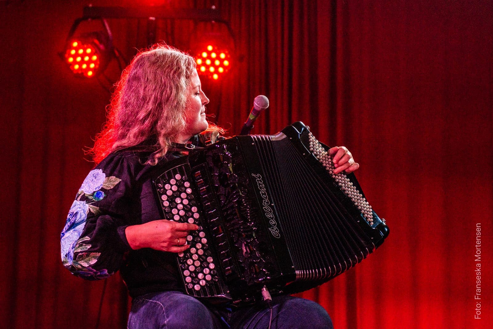 Mette Kathrine Stærk playing the accordion in red light
