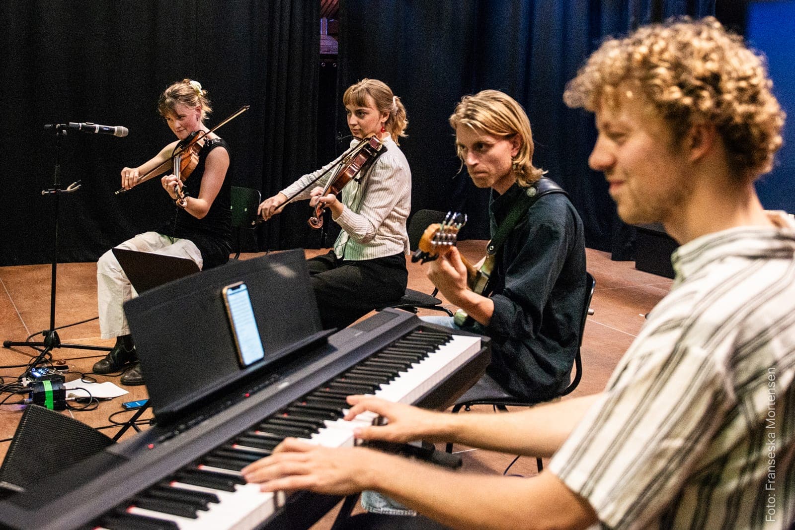 Unge musikere spiller violin, guitar og klaver ved Aarhus Folk Festival 2025