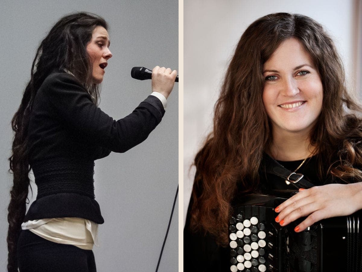 Jullie Hjetland synger i en mikrofon set fra siden, og Mette Kathrine Stærk smiler med armen hvilende på sin harmonika