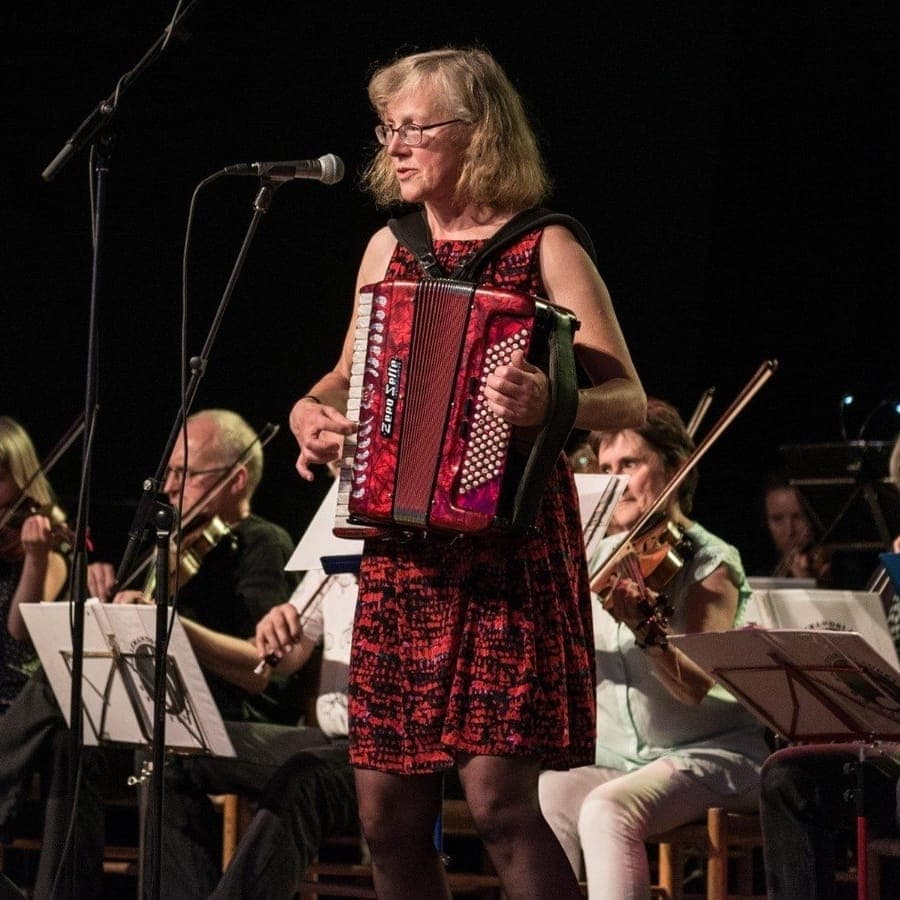 Hanne Eriksen spiller harmonika sammen med et spillemandsorkester