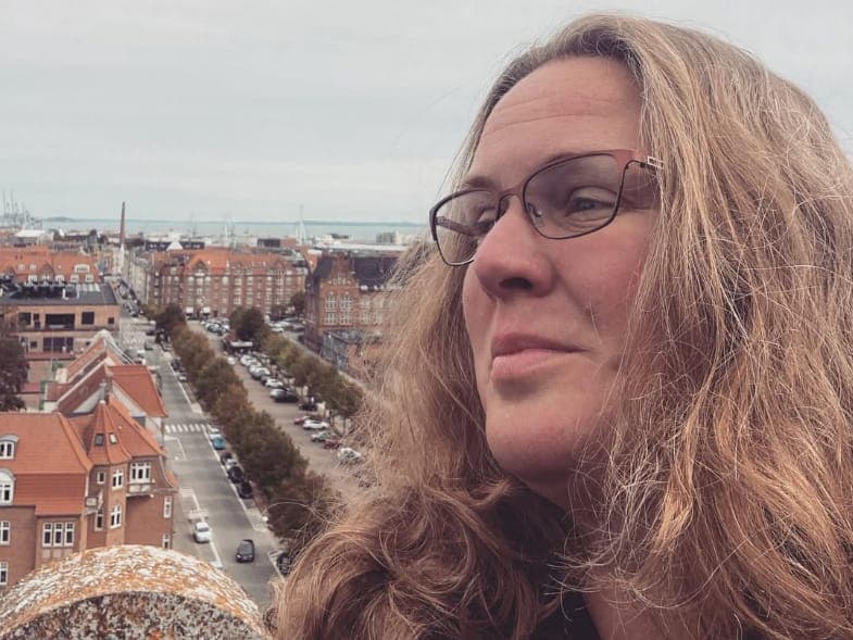 Maria Louise Bøg Sørensen med briller og udsigt over Aarhus i baggrunden