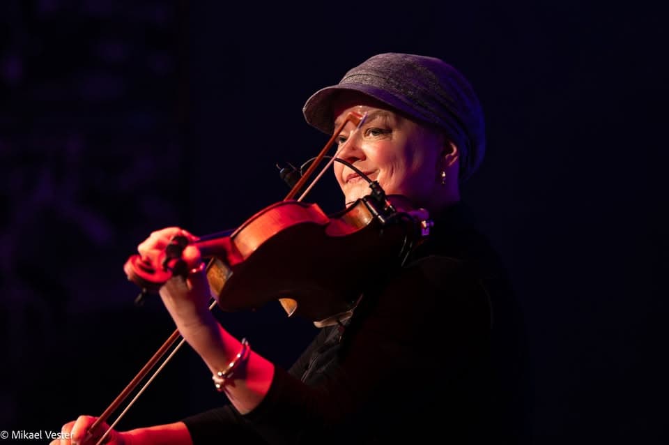 Violinist med hat på en mørk scene, fotograferet af Mikael Vester